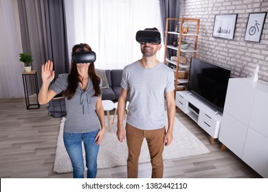 Young Couple Using Virtual Reality Device At Home