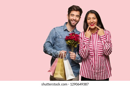 Young couple in valentines day smiles, pointing mouth