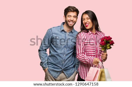 Young couple in valentines day winking, funny, friendly and carefree gesture