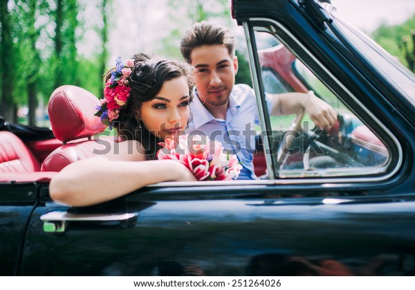 Young couple in vintage\
cars