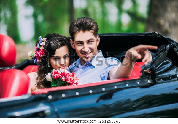 Young couple in vintage\
cars