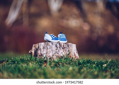Young couple waiting for baby. Expecting parents with little baby boy shoes. Concept of Parents-To-Be. Shoes and sneakers of parents and expected baby. Mom, dad and the future baby Shoes.
