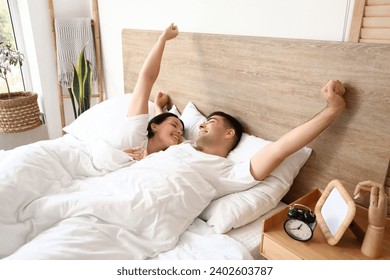 Young couple waking up in bedroom - Powered by Shutterstock