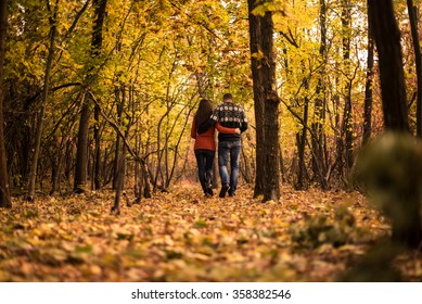 Young Couple Walking In The Autumn Park