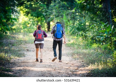 Young couple walking with backpacks in forest. Adventure hikes, Enjoy holidays together, Couple in love.