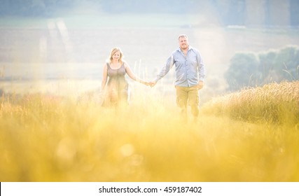 Young Couple Walking between Golden Grain Fields - Soft and Light