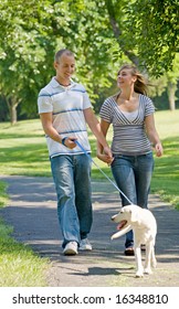 Young Couple Walking Dog