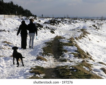 Young Couple Walking With Dog In The Hole Of Horcum, North Yorkshire, England, UK.