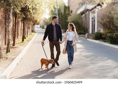 Young couple walking down stairs with their dogs on a city street - Powered by Shutterstock