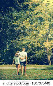 Young couple walking in a green park. Vertical image of lovers dating
