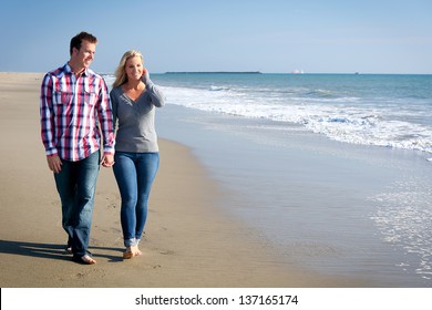 Young Couple Walking On The Beach