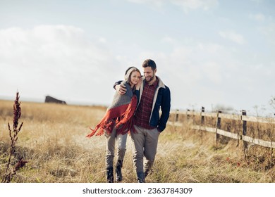 Young couple walking on a field on a farm in the countryside