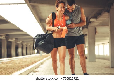 Young Couple Walking On Street In Sports Wear.They Going To Gym.