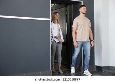 Young Couple Walking Out Of Modern Elevator