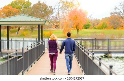 Young Couple Walking In Park In Fall In Midwest; Caucasian Woman And Asian Man