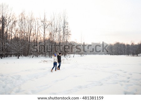Young couple walking in the snowy forest