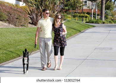 Young Couple Walking Their Dog