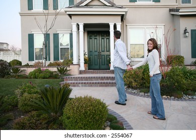 A Young Couple Walking Up To Their New Home