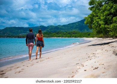 young couple walks holding hands on the beautiful beach in costa rica - Shutterstock ID 2202592117