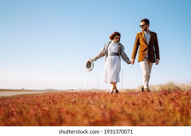 Young Couple Walks In The Park During The Spring And Hugs. Enjoying Time Together. The Concept Of Youth, Love And Lifestyle.