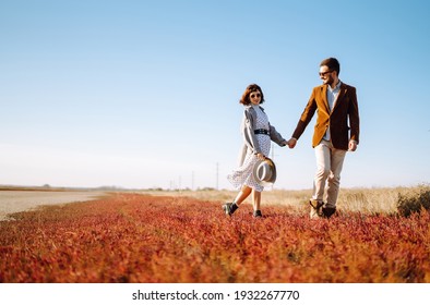 Young Couple Walks In The Park During The Spring And Hugs. Enjoying Time Together. The Concept Of Youth, Love And Lifestyle.