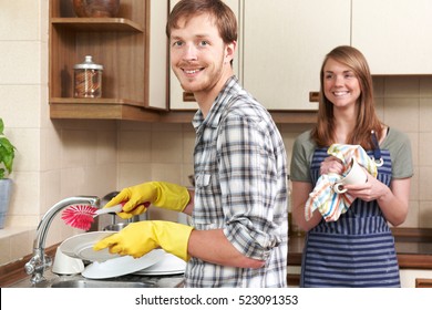 Young Couple Washing Up At Sink Together