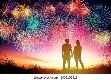 Young Couple Watching Fireworks On Hill