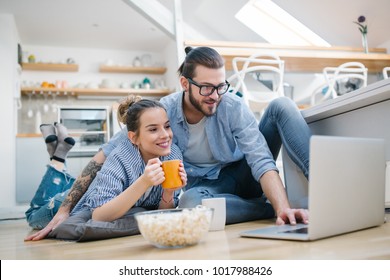 Young Couple Watching Movie On Laptop At Home
