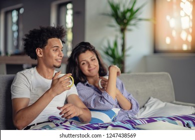 Young couple watching a movie on their laptop in bed - Shutterstock ID 1247438569