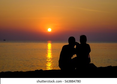 Young couple watching the sunrise in the morning.
