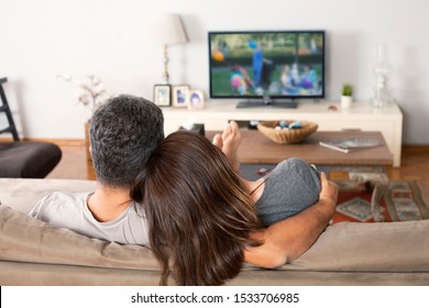 young couple watching tv at home