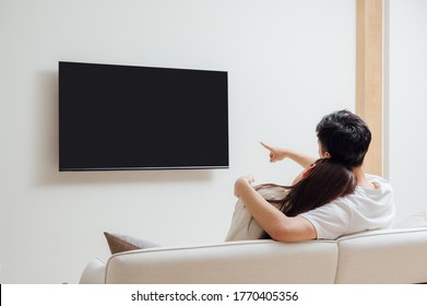 Young couple watching TV at home