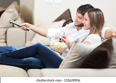 Young couple watching tv on a sofa