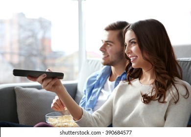 Young Couple Watching TV On A Sofa At Home