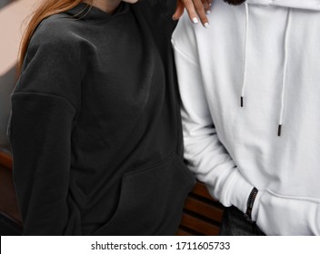 Young Couple Wear Hoodies. Man Has White Hoodie. Girl Has Black Hoodie