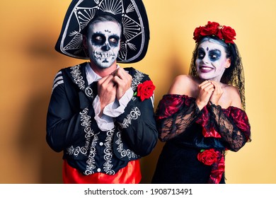 Young Couple Wearing Mexican Day Of The Dead Costume Over Yellow Laughing Nervous And Excited With Hands On Chin Looking To The Side 