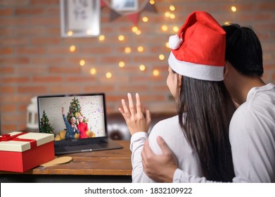 A young couple wearing red Santa Claus hat making video call on social network with family and friends on Christmas day. - Powered by Shutterstock