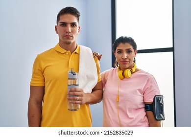 Young Couple Wearing Sportswear And Headphones Thinking Attitude And Sober Expression Looking Self Confident 