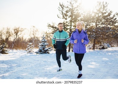 Young couple winter morning exercise at snowy forest.  Healthy fitness lifestyle. Sport, Active life.