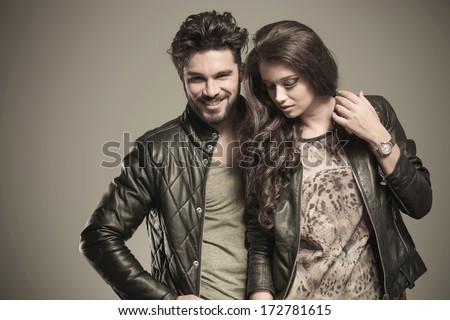 young couple, woman looking down and man smiling at the camera