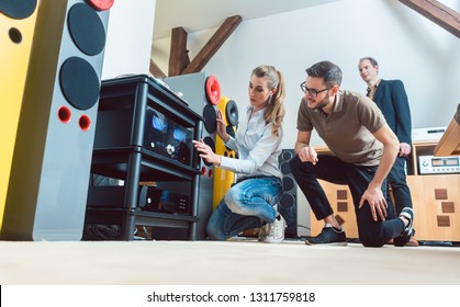 Young couple, woman and man, buying high-end stereo equipment in store