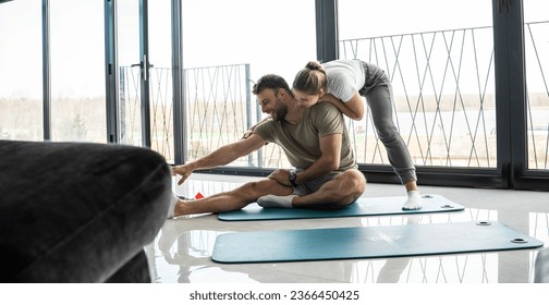 Young couple working out and practicing yoga in the comfort of their own home.	
 - Shutterstock ID 2366450425