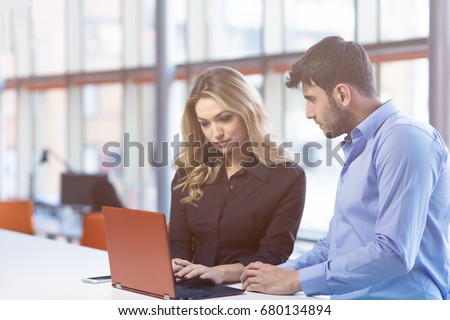 Young couple working together on a laptop in the office. Teamwork concepts.