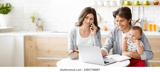 A young couple works from home in their kitchen. The woman is on a phone call, while the man is working on a laptop, holding their baby on his lap. The baby is looking at the laptop screen - Powered by Shutterstock