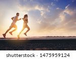 Young couples running sprinting on road. Fit runner fitness runner during outdoor workout with sunset background