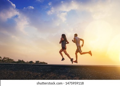 Young couples running sprinting on road. Fit runner fitness runner during outdoor workout with sunset background - Shutterstock ID 1475959118