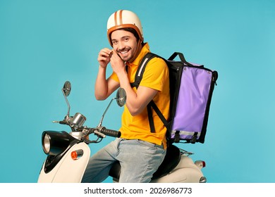 Young Courier, Delivery Man In Uniform With Thermo Backpack On A Moped Isolated On Blue Background. Fast Transport Express Home Delivery. Online Order.