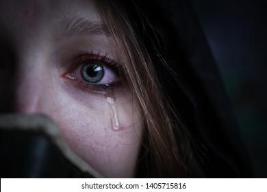 Young covid \ coronavirus survivalist crying woman in gas mask with red eyes and tears on her face looking into camera close up portrait 