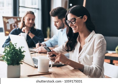Young coworkers. Young modern colleagues in smart casual wear working while spending time in the office - Shutterstock ID 1059175031
