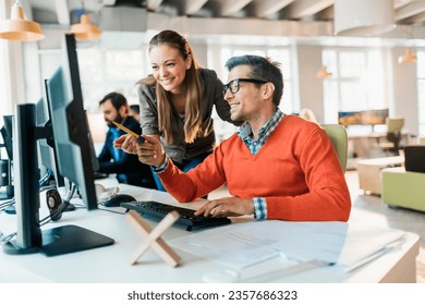 Young coworkers using the computer in a startup company office - Powered by Shutterstock